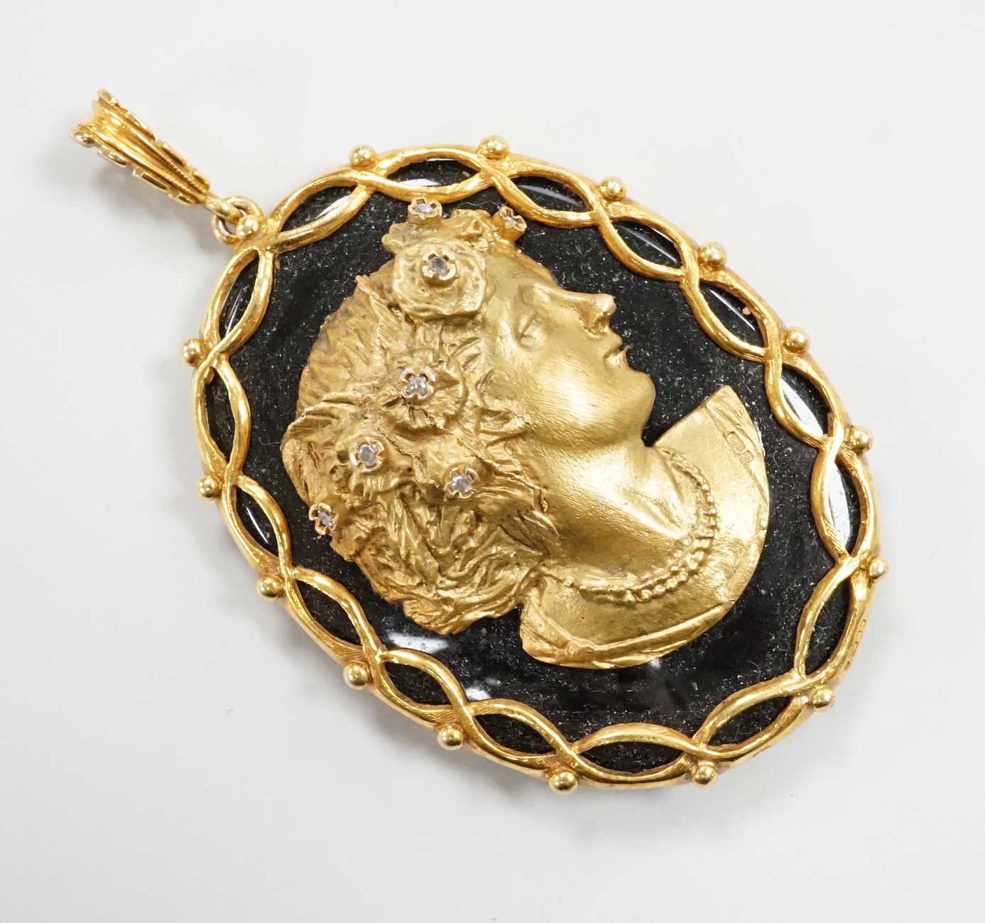 A modern 9ct gold, and diamond set black onyx pendant, decorated with the bust of a lady in relief, overall 66mm, gross weight 35.4 grams.